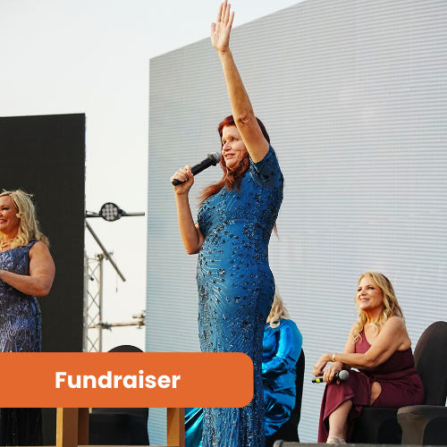 Woman holding hand up wearing a blue dress